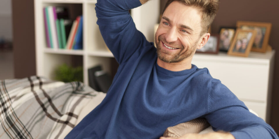 Handsome man relaxing with cup of coffee at home